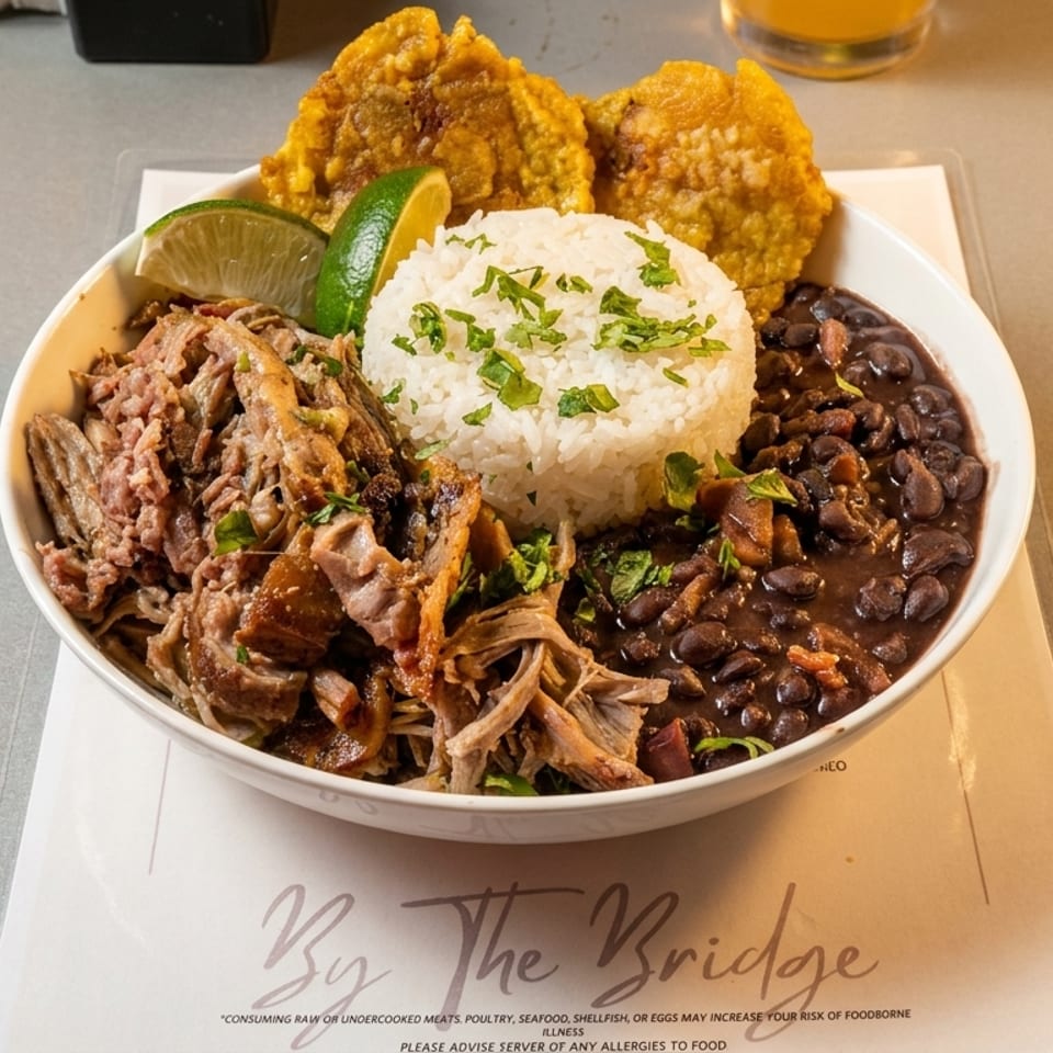 A Cuban dish from By The Bridge with shredded pork, rice, black beans, and plantains.